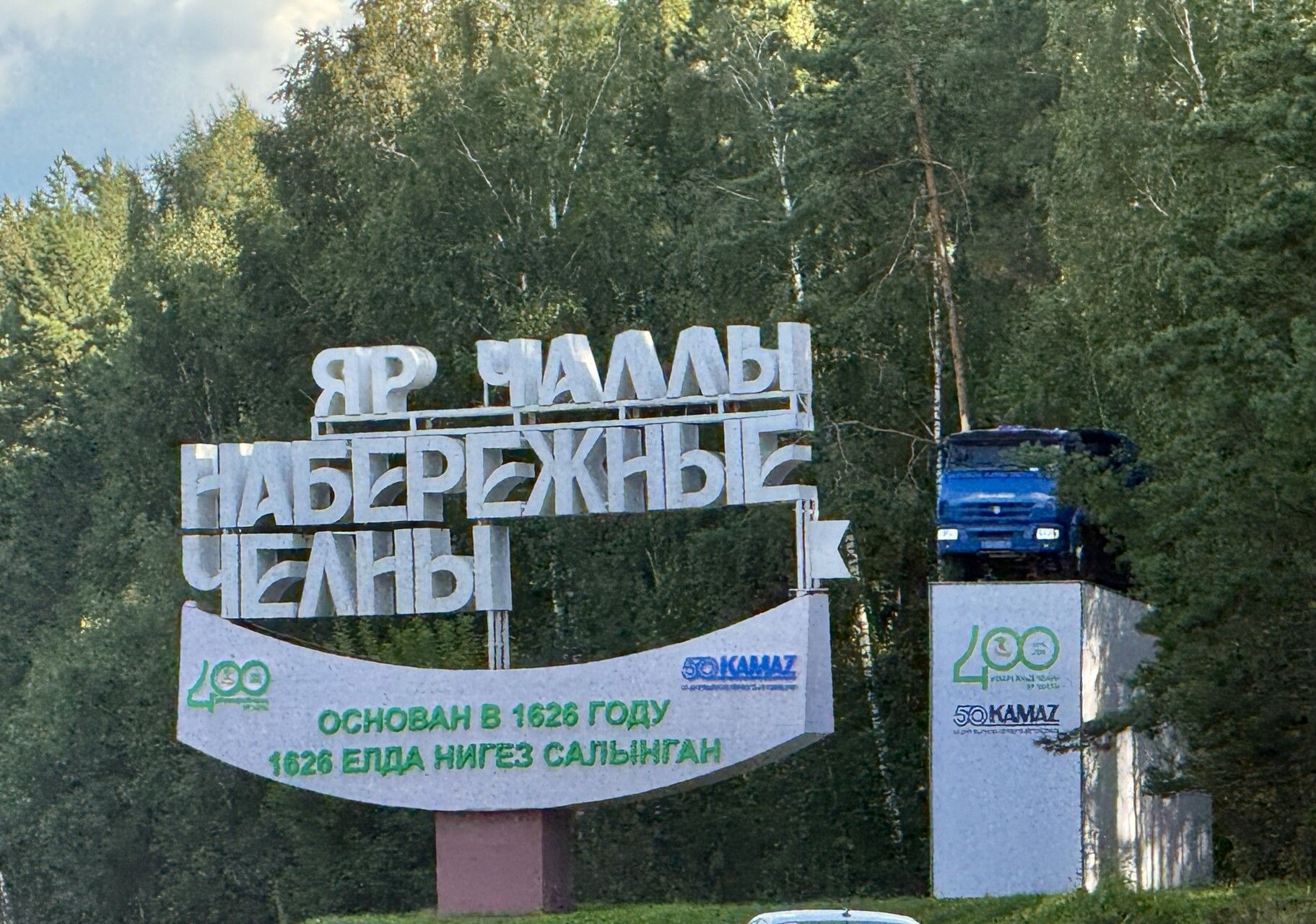 Рядом с надписью установлен грузовик КАМАЗ