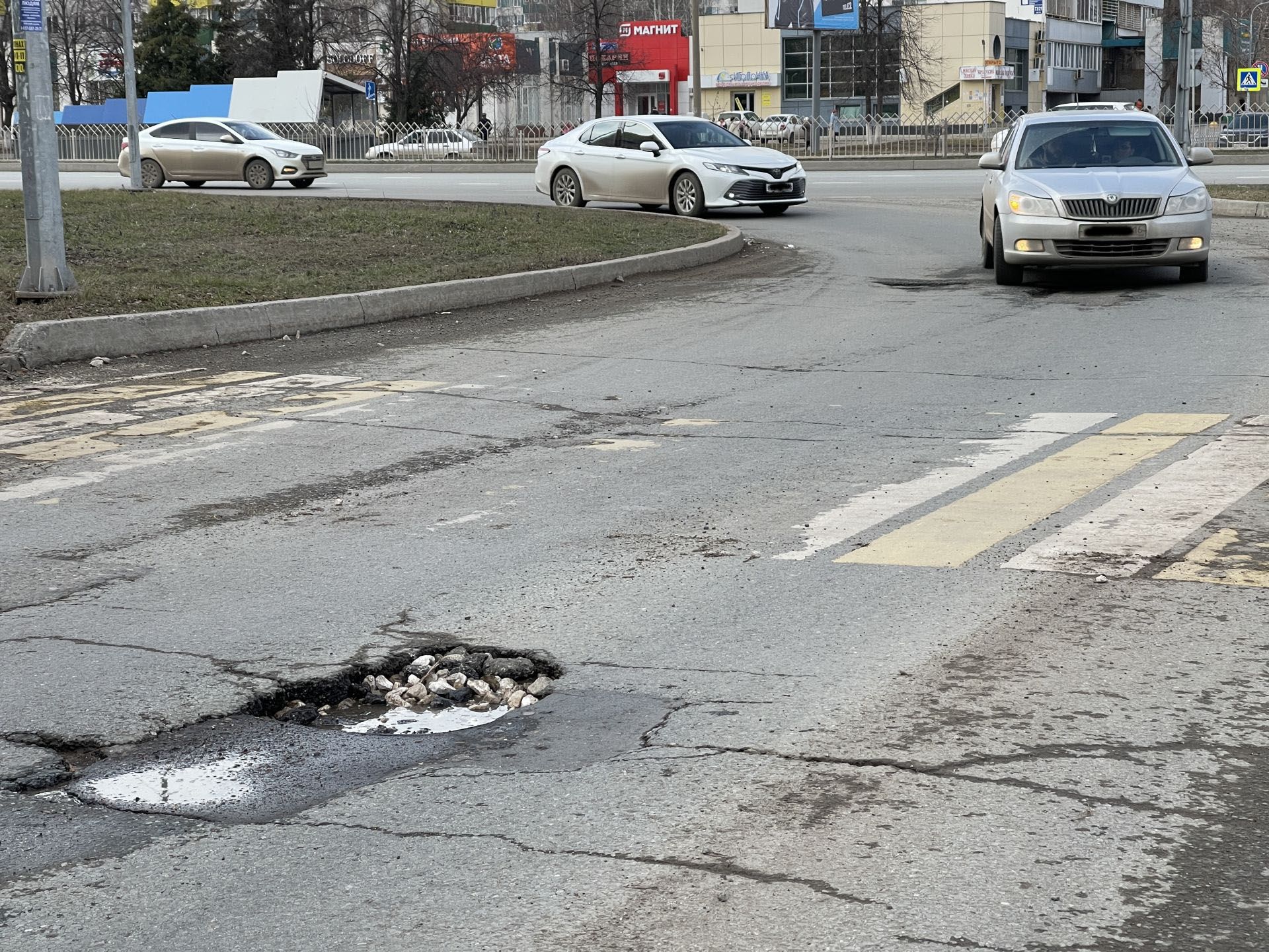 В Киеве водитель скутера влетел в яму и едва не попал под машину, видео